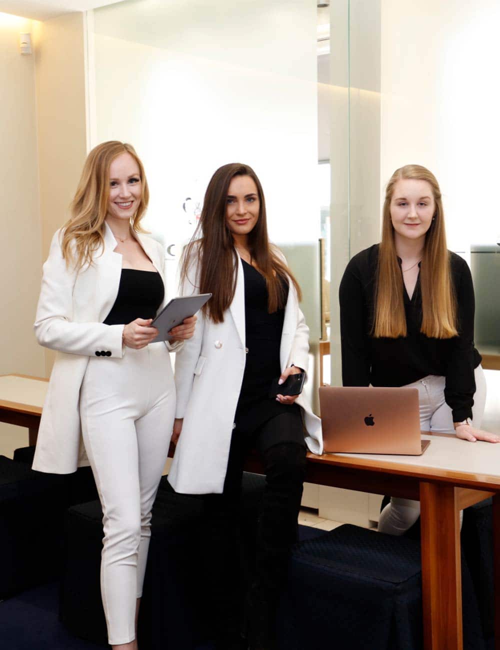 Drei Frauen stehen mit einem Laptop und Tablet im Verkaufsraum des Juwelier Kopp